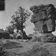 A view of the sandstone formation, Balanced Rock, in the Garden of the Gods, west of  Colorado Springs, Colorado. A burro and a bicycle are in view.