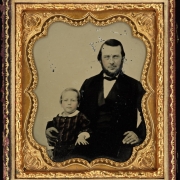 Studio portrait (sitting) of a man and his son.