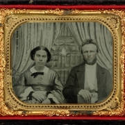 Studio portrait (sitting) of a husband and wife.  The woman wears a lace collar.