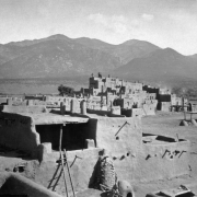 View of north house cluster, Taos Pueblo, New Mexico; shows Native American (Taos) adobe dwellings, ovens, and Pueblo Peak and the Taos Mountains.