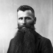 Head and shoulders portrait of Doc Middleton, with a long beard and wearing a jacket and vest with a watch chain. A notorious horse thief, murderer, and legitimate business man, he used the aliases of Jim Cherry, James Shepherd, Jack Lyons, and Jim Riley when he committed crimes.