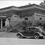 View of the powerhouse in City Park, Denver, Colorado. An automobile is parked nearby.