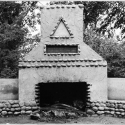 View of a stone and cement grill and chimney in Washington Park, Denver, Colorado. A sign above on the chimney reads: "Presented To The City & County of Denver By The Denver Campfire Girls".