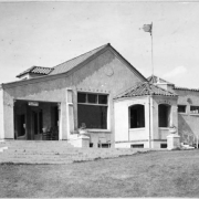 View of the club house at the Willis Case Municipal Golf Course (formerly Rocky Mountain Golf Course). The building has a tile roof and covered porch. A sign on the building reads: "Buy Tickets Inside".