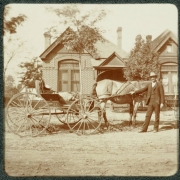 A man poses by a horse-drawn buggy in front of his house in Denver, Colorado.