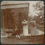 A father and his daughters eat watermellon outdoors near their house in Denver, Colorado.