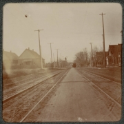 View of a street in Denver, Colorado. Houses line the street and a trolley car is in the distance.