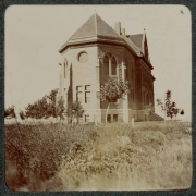 View of a church in Denver, Colorado. The stone building has circular and arched windows.