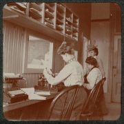 Women work in an office in Denver, Colorado. They sit at typewriters and wear long dresses.