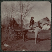 A man sits in a horse-drawn wagon as his son sits on the horse in Denver, Colorado.