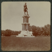 Women pose on the base of a statue of Robert Burns in City Park, Denver, Colorado.