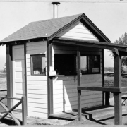 View of the starter's building on the first tee at the Wellshire Golf Course (Wellshire Country Club) in Denver, Colorado. A wooden bench is nearby.