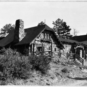 View of the Chief Hosa lodge, built as a restaurant by the city of Denver, at Genesee Park, part of the Denver Mountain Parks System (Jefferson County), Colorado. The stone masonry building has a covered entryway and a stone chimney.