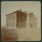 View of a possibly a school building probably near Denver, Colorado. A flagpole is on the roof.