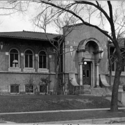 A view of the Henry White Warren Branch Library located at 34th and High Street in Denver, Colorado. The Warren branch was designed by the Fisher Brother's architects and features an Italian style design with a red tiled roof, brick foundation and cement walls. This branch opened in 1913.