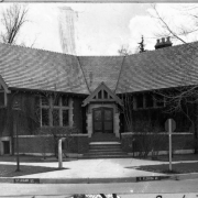 A view of the Sarah Platt Decker Library Branch located in James H. Platt Park on Iowa and Logan streets in Denver, Colorado. The Decker library branch was constructed in 1913. The V-shaped English cottage features tiled roof, raised courtyard, gabled entry, chimneys and concrete trim. The branch was named for Sarah S. Platt Decker, a suffragette, club woman, and civic benefactor.