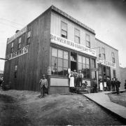View of businesses at 2433 16th (Sixteenth) Street between Platte and Central (later west Eleventh Avenue) in Denver, Colorado; shows men and girls posing, an electric light, and signs: "Beer Depot Union Brewing Co.," "Depot Rooming House Denver Head Quarters Albert Fette Prop.," "Depot Restaurant."