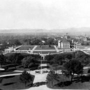 View of Civic Center in Denver, Colorado. The Greek Theater and Colonnade of Civic Benefactors and the Voorhies Memorial are on either side of the grassy area bisected by walkways. The Denver Public Library is in the park.