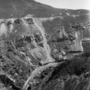 Belden mine complex and Denver and Rio Grande Western Railroad tracks flank the Eagle River, at Gilman (Eagle County), Colorado; mining buildings dot surrounding cliffs.