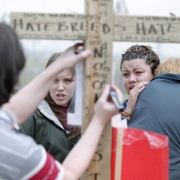A woman writes a derogatory message on Dylan Klebold's cross near Columbine.