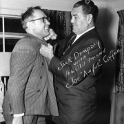Jack Dempsey poses with Joe "Awful" Coffee probably in Colorado. Both men wear suits.