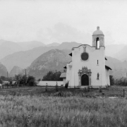 The Pauline Chapel at the Hotel Broadmoor, El Paso County, Colorado, is a mission-style building with cupola, tile roof, ornate-carved stone door frame, and niche-sculpture of Saint Paul.