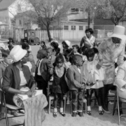 Women who include Fairfax Holmes site near a group of children at the dedication ceremony for the George Washington Carver Day Nursery at 2260 Humboldt Street in the City Park West neighborhood of Denver, Colorado.