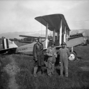 View of men in coveralls (with goggles) and a biplane with letters: "U.S. Navy A-6391," as part of Oil Shale Day in Nada, Garfield County, Colorado.