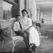 A woman and a boy, Doug Ellis, sit on a porch bench at 1172 Gaylord Street in Denver, Colorado.