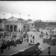 View of the White City amusement park (later named Lakeside) west of Denver, Colorado; shows crowds of people, railway pavilion, banners, and roller coaster.