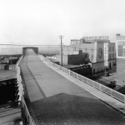 View of the Broadway Viaduct in Denver, Colorado. A sign on a nearby building reads: "The McMurtry Mfg. Co. Paint & Var[nish] Makers."