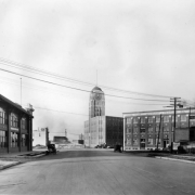 View of the entrance to the Broadway Viaduct in Denver, Colorado. The McPhee McGinnity Building is near the bridge. Signs on and near buildings read: "The Silver State Laundry Co.," "Minehart-Traylor Co.," and "Joel L. Shackelford Realty Company."