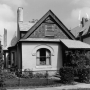 View of a house at 2521 Champa Street in the Five Points neighborhood of Denver, Colorado. The one-story brick house has a half turret and decorative window arch.