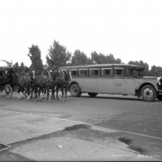 Publicity shot in Boulder, Colorado, used to promote modern motorcoaches over interurbans; shows new and old coaches parked on paved bridge, a Wells Fargo Company Stagecoach drawn by a team of horses with men  driving; an autobus labeled "The Denver & Interurban Motor Co. 27", on door "Bonded Carrier," over the windshield "Special;" curtains in windows and luggage rack on top; license plate reads Colo. 1925 or 1926 [?].