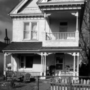 View of 2825 Curtis Street in the Curtis Park neighborhood (Five Points) in Denver, Colorado; shows a frame house with shingle imbrication and a covered porch and balcony.