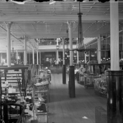 Interior view of the Daniels and Fisher store, in Denver, Colorado; shows glass display cases, umbrellas, lamps, and a mezzanine.