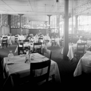Interior view of the Daniels and Fisher store in Denver, Colorado; shows the dining room, tables with silverware and carafes, and wooden screens.