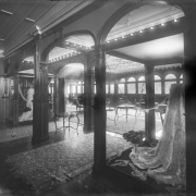 Interior view of the Daniels and Fisher store in Denver, Colorado; shows a room with stained glass windows, coffered ceilings, lace, tables, chairs, and Oriental rugs.