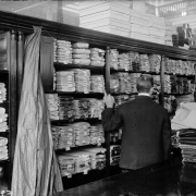 Interior view of the Daniels and Fisher store, in Denver, Colorado; shows bolts of fabric in shelves, and a clerk.