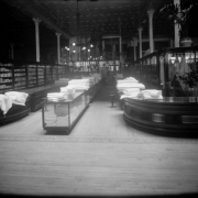 Interior view of the Daniels and Fisher store in Denver, Colorado; shows linen, glass display cases, and a wood parquet floor.