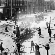 View of 16th (Sixteenth) Street, in Denver, Colorado; shows bicycle and pedestrian traffic, and horse drawn wagon with a band, part of the Festival of Mountain and Plain parade.