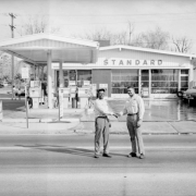 Two African American (Black) men shake hands in front of a Standard gas station at 29th and Colorado Boulevard in the Five Points neighborhood of Denver, Colorado.
