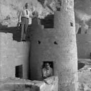 Interior view of Native American (Anasazi) Cliff Palace, at Mesa Verde National Park, Colorado; shows men in ties and hats posing by ruins of a round tower.