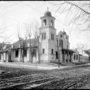 View of St. Patrick's Catholic Church at 3325 Pecos Street, Denver, Colorado; Sells & Weber grocery store building advertises Uneeta Biscuit (3341 Pecos Street).