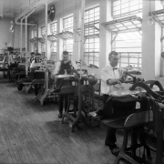 Interior view of a laundry, in Denver, Colorado; shows men and a woman working with steam presses.