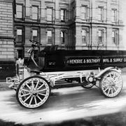 View of a Hendrie and Bolthoff Manufacturing Supply delivery truck parked near the Colorado State Capitol building in Denver, Colorado. Lettering on the open-cab truck reads: "22 The Hendrie & Bolthoff Mfg. & Supply Co."