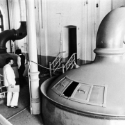 Interior view of the abandoned Tivoli-Union Brewery in Denver, Colorado; shows beer vats, stair railings, and men.