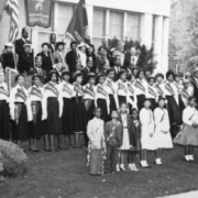 African-American men, women, and children, members of the American Woodmen's Association and Shriners, many in costume or uniform, pose with banners and pennants near the Association's office at 2100 Downing Street in the Five Points neighborhood of Denver, Colorado.