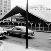 View of May D & F Company construction in Denver, Colorado; shows the parabola roofed addition at Zeckendorf Plaza designed by architect I. M. Pei. Cars are on Tremont Street.