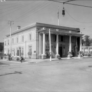 View of "The Olinger Mortuary" at 16th (Sixteenth) and Boulder Streets in the Highland neighborhood of Denver, Colorado; shows a brick building with urns, columns, and a balustrade.